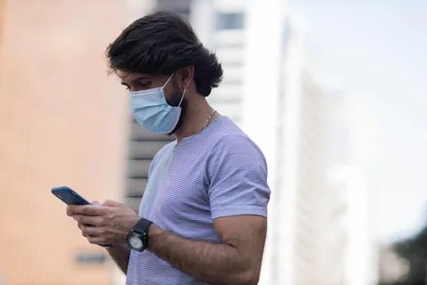 View of young man using a smartphone at day time with city view landscape in  Stock Photos