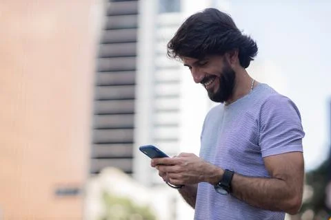 View of young man using a smartphone at day time with city view landscape in  Stock Photos