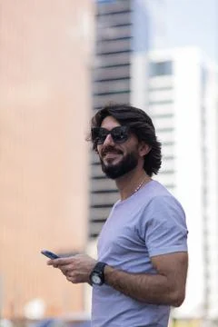 View of young man using a smartphone at day time with city view landscape in  Stock Photos