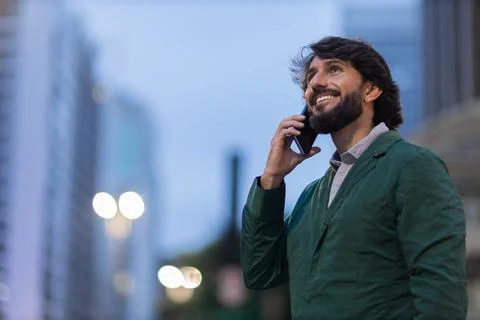 View of young man using a smartphone at night time with city view landscape i Stock Photos