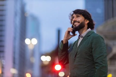 View of young man using a smartphone at night time with city view landscape i Stock Photos