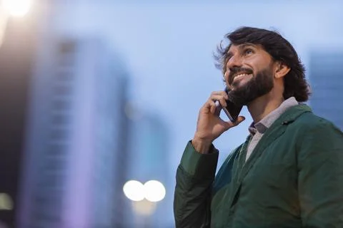 View of young man using a smartphone at night time with city view landscape i Stock Photos