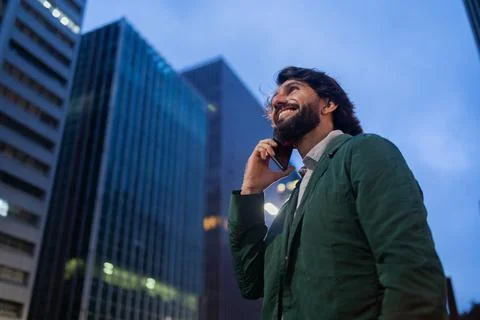 View of young man using a smartphone at night time with city view landscape i Stock Photos