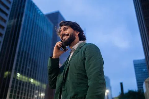View of young man using a smartphone at night time with city view landscape i Stock Photos