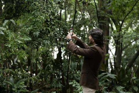 View of young man using a smartphone at twilight Stock Photos