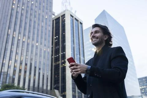 View of young man using a smartphone at twilight Stock Photos