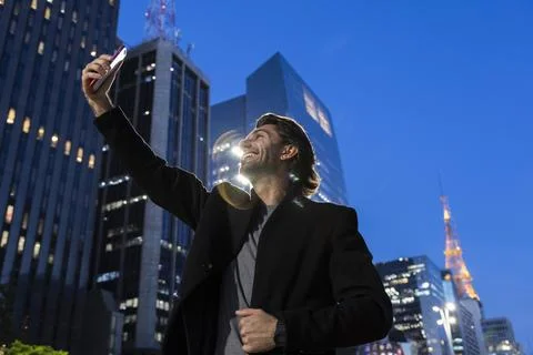 View of young man using a smartphone at twilight Stock Photos