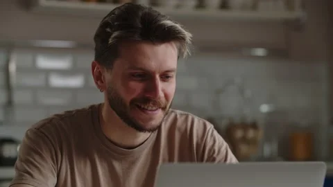 View of a young man working at a computer. Smiling male freelancer working Stock Footage 238922256