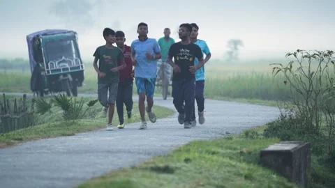 View of young men jogging on a rural road in Bogura, Bangladesh. 스톡 동영상 335550380