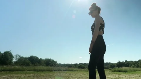 View of young pretty brunnette doing ballet in green fields on sunny summer day. Stock Footage 134041987