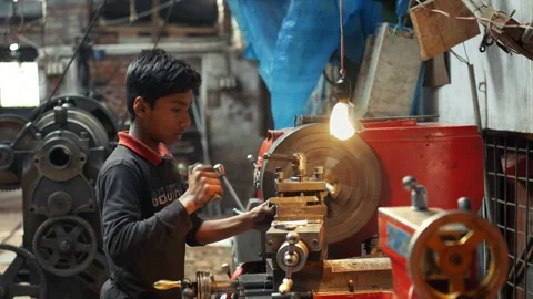View of a young worker operating a lathe machine in a workshop, Bangladesh. Stock Footage 335584674