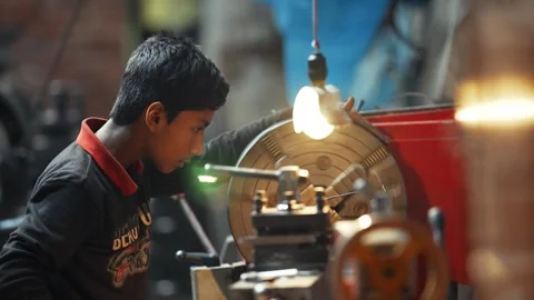 View of a young worker operating a lathe in a workshop, Bangladesh. Video stock 335584787