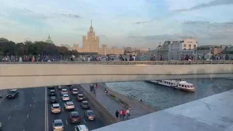 View of zaryadye park floating bridge with people walking, traffic on the ro Stock Footage 147199225