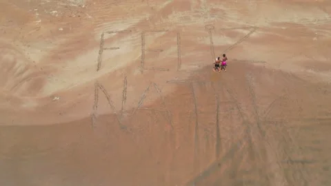 Viewed from above, two young Africans walking on the sand with the inscription Stock Footage 332103796