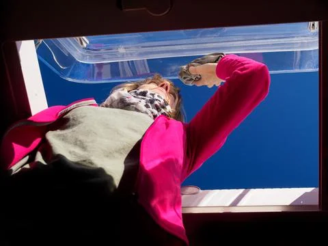 Viewed from below a lady cleans a skylight window of her recreational vehicle Stock Photos