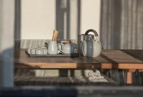 Viewed through an open window frame, a minimalist ceramic tea set rests qui.. 스톡 사진