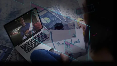 Viewer comparing charts with laptop while host showing paper and HUD marking Stock Footage 333963345