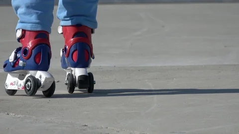 Viewing a child in three wheels rollerskates walking away and looking back Video stock 106722764