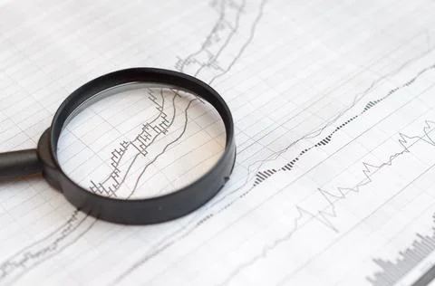 Viewing forex charts through a magnifying glass. Stock Photos