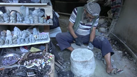 Viewing an old man making stone figurines for sale Stock Footage 165861892