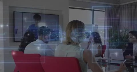 Viewing remote presenter on screen, team sitting around glass table in office Stock Photos