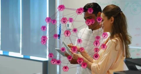 Viewing two coworkers in shirts using tablet in office with AR overlay and Stock Photos