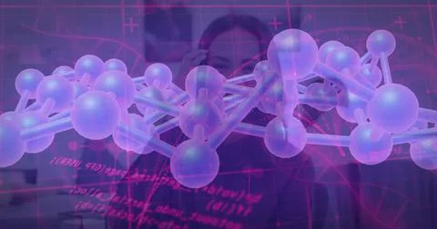 Viewing two scientists wearing dark clothing adjusting holographic molecule in 写真素材