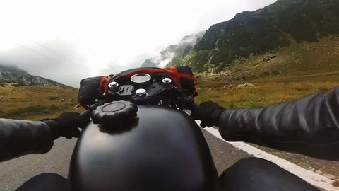 Viewpoint of a motorcyclist riding down a scenic road toward the mountains. Video stock 78226567
