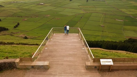 Viewpoint on a road. Two people look on green valley from the top of mauntain 스톡 동영상 121270764