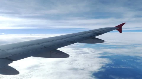 Viewpoint Wing of windows airplane flying above the clouds in the sky Stock Footage 64930698