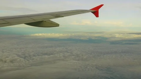 Viewpoint Wing of windows airplane flying above the clouds in the sky Stock Footage 77188359