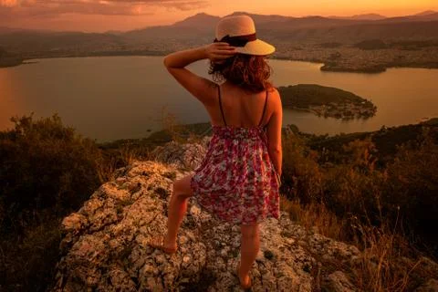 Viewpoints to capture memorable sunsets. Young woman in colorful dress and ha Stock Photos