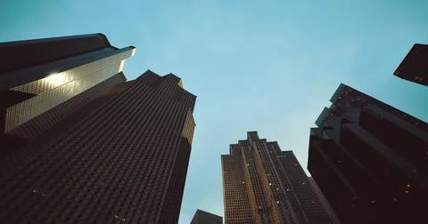 Views from below the towering buildings in the downtown area during twilight Stock Illustration