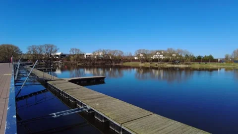 Views of the calm water and dock at a lakeside area during daytime in a quiet to Vídeos de archivo 332636680