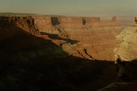 Views of a canyon with deep cliffs and shadows in a dry landscape at sunset Stock Photos