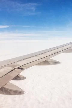 Views of a cloud-covered landscape from an airplane wing during a daytime flight Stock Photos