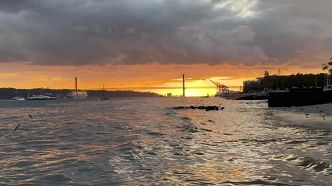 Views from the commerce square at sunset and 25 de abril bridge in background. Video stock 307210122