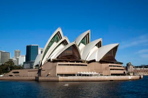 Views of harbour including the iconic opera house under a blue sky Stock Photos