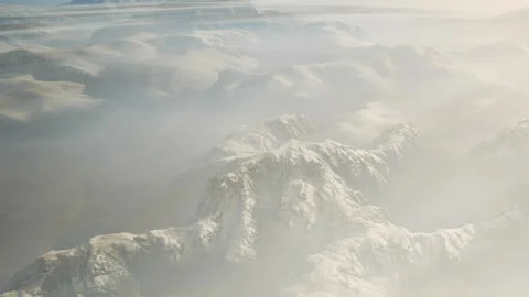 Views of mountains covered in snow with clouds floating over the landscape Stock Footage 345014286