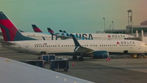 Views of multiple Delta Airlines aircraft parked from window of taxiing plane Stock Footage 256920124