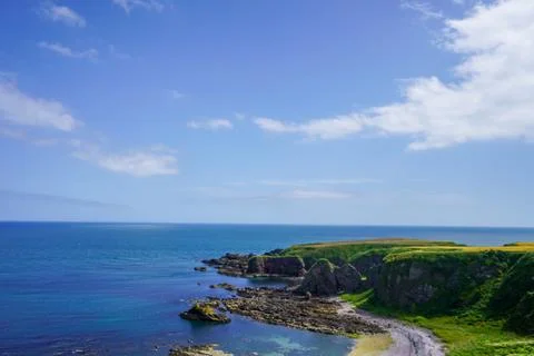 Views over fields and coast line rocks in Scotland Photos