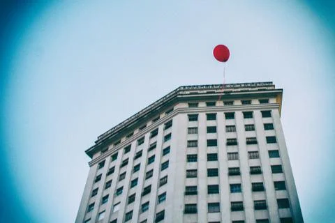 Vignette effect of a red balloon flying in front of an old building. Stock Photos