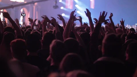 Vigorous audience dancing with hands up at the concert Stock Footage