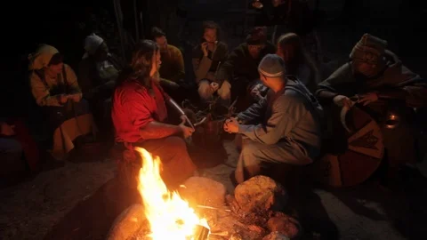 Viking-Age Village Reenactment In Sweden. Vikings Socializing Around A Fire In Stock Footage