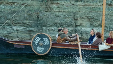 A Viking Man Sits at the Stern of the Drakkar and Sings. Medieval Reconstruction Stock Footage 163964853