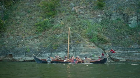 Vikings Sail on an Old Ship with a Lowered Sail on a Quiet River Stock Footage 156554627