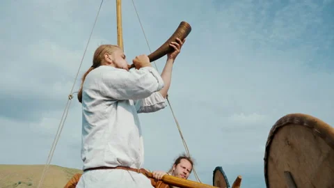 Vikings Sail on an Old Ship with a Raised Sail on a Calm River Video stock 163966243