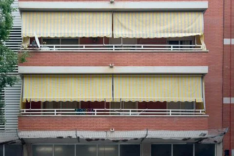Viladecans.Barcelona - July 28, 2025: Edificio con toldos de rayas amarillas Stock Photos