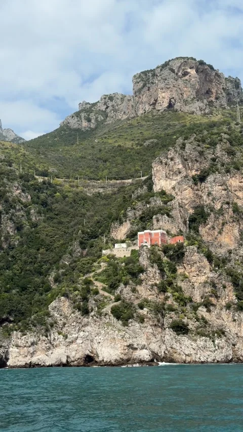 Villa perched on the cliffs of the Amalfi Coast viewed from a moving boat,  Stock Footage 332973655