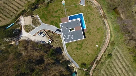 Villa with the pool. Man doing workout on helipad on roof. Capoeira. Aerial view 스톡 동영상 129792086
